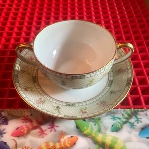AN ANTIQUE T & V TWO HANDLE FLORAL TEACUP AND SAUCER